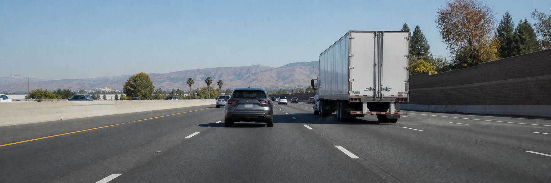 Passenger vehicle and semi-truck travelling safely on a California freeway